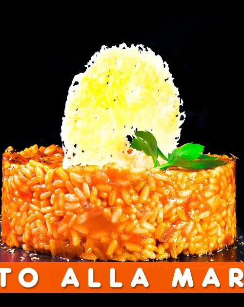 Risotto alla marinara con acciughe e pomodoro servito in un piatto rustico