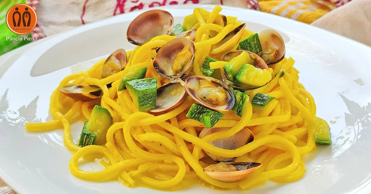 Tonnarelli con vongole e zucchine serviti in un piatto chiaro